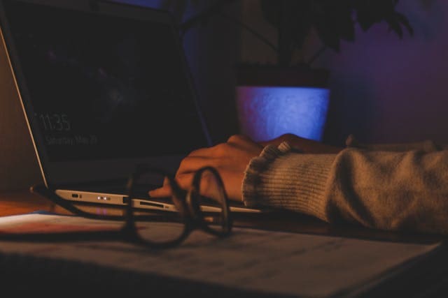 Strategic Risk Management Business professional working on a laptop with risk management documents.